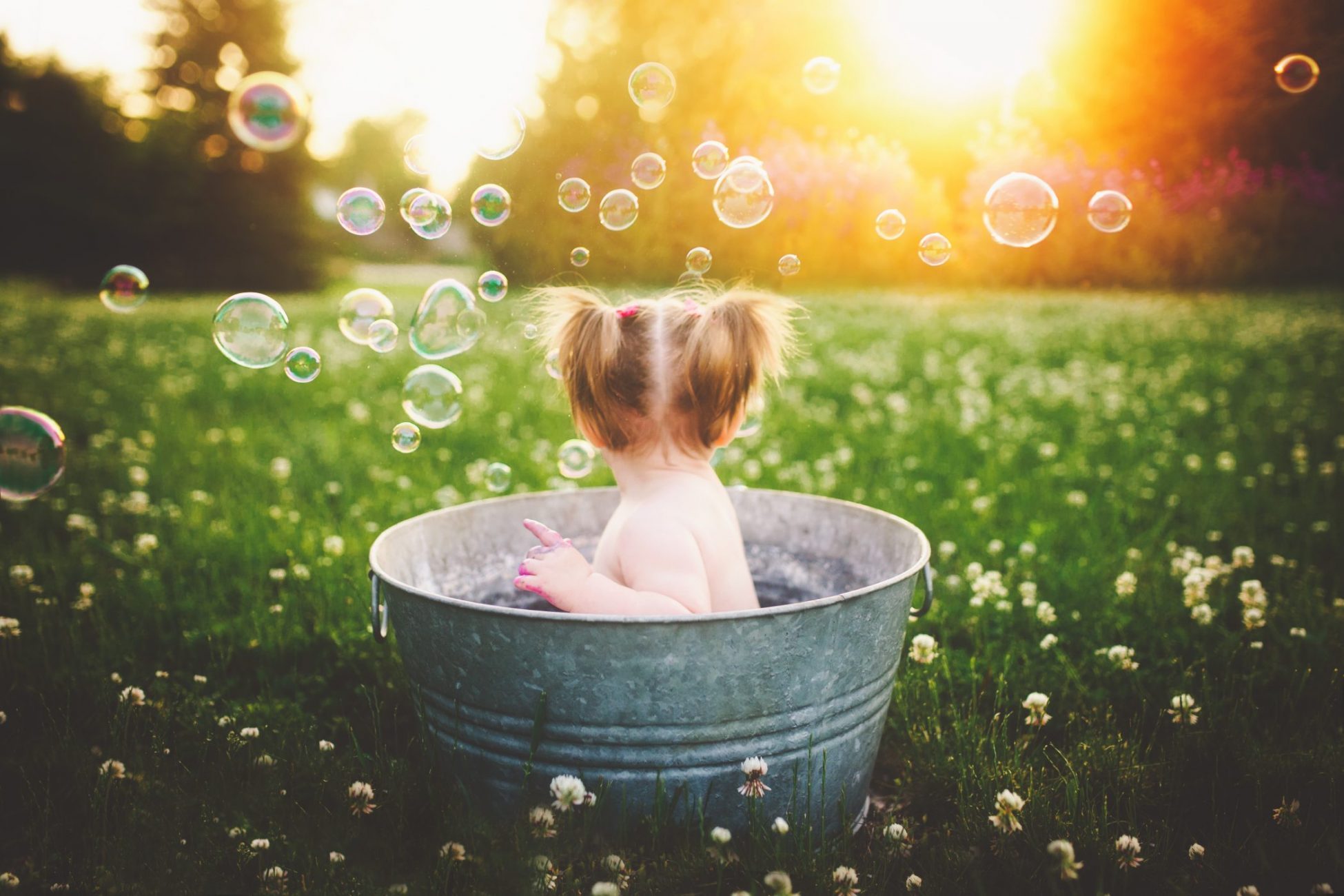 a little girl sitting in a tub filled with bubbles, photography in Ventura