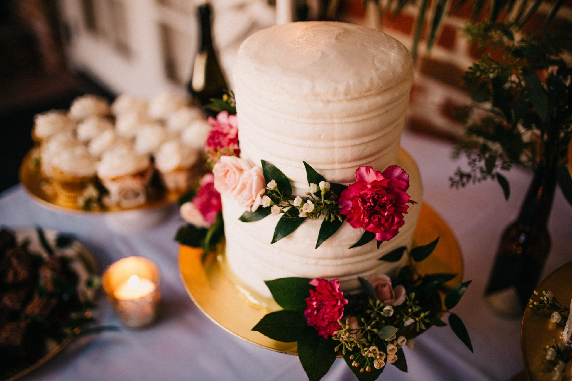 a wedding cake with pink flowers on a yellow plate